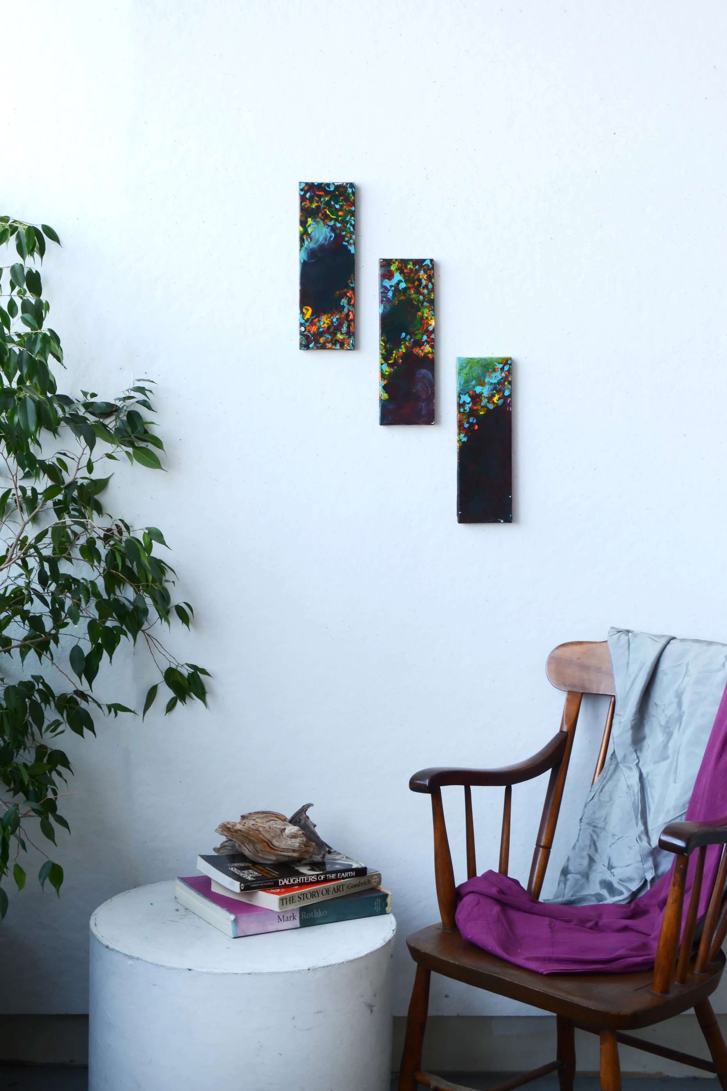 Three black colorful paintings on wall