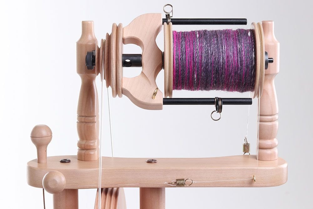 Spinning some hand-dyed wool into yarn using a wooden spinning wheel #