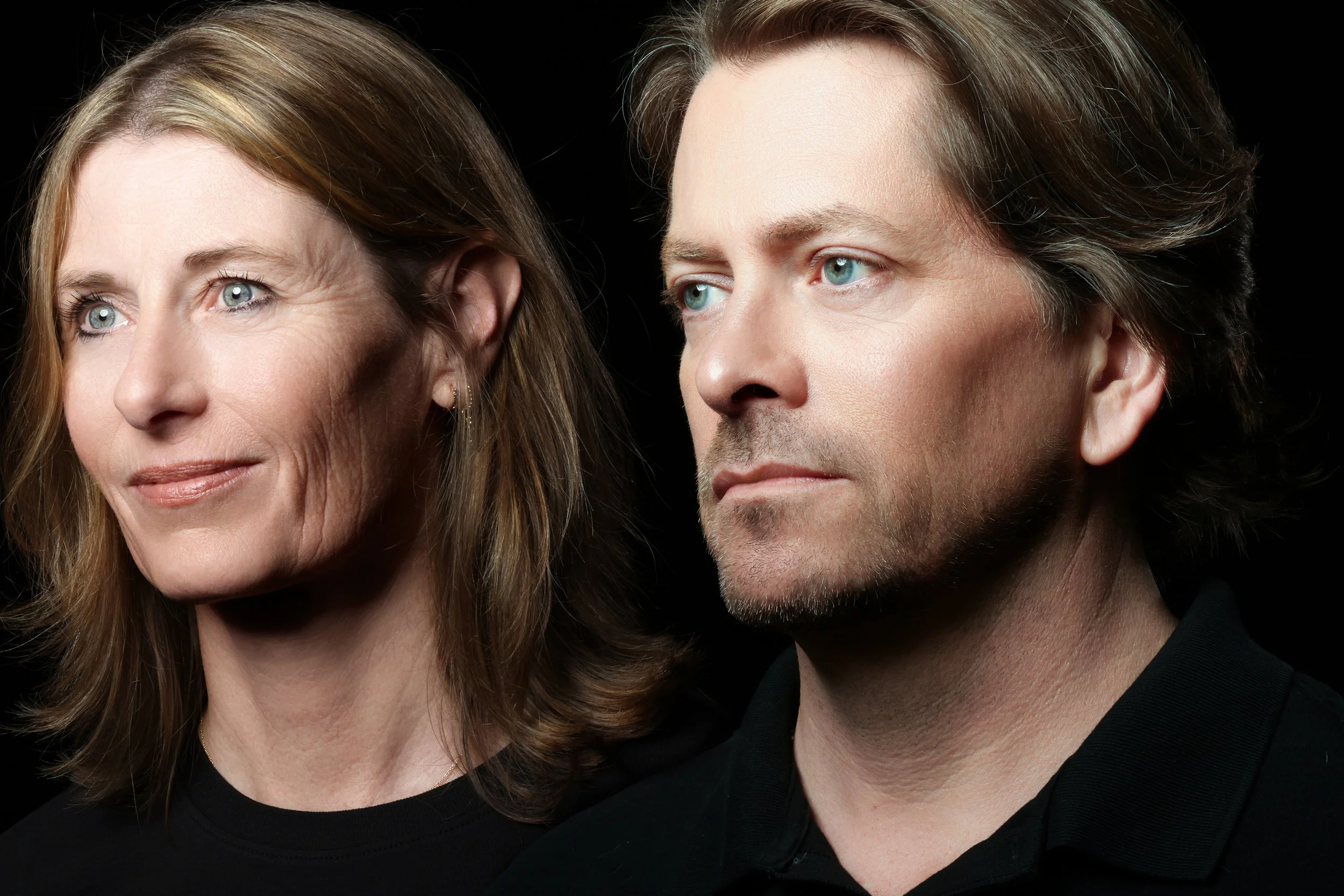 A close-up portrait of a middle-aged woman with shoulder-length light brown hair and blue eyes next to a middle-aged man with wavy brown hair and blue eyes, both against a black background.