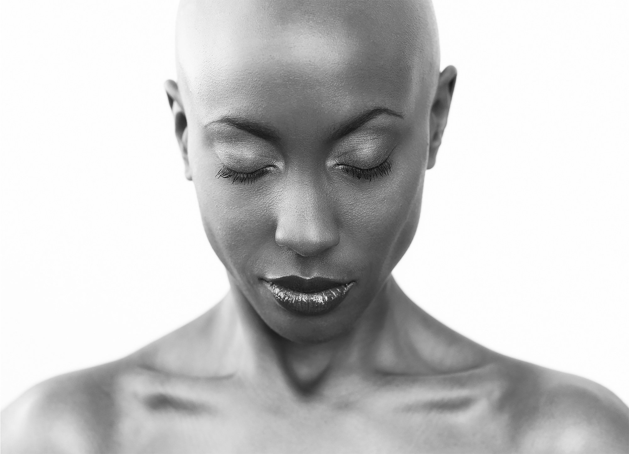 Close-up of a woman with bald head, closed eyes, and dark lipstick, in black and white.  Image by top Los Angeles photographer Kenneth Dolin. 