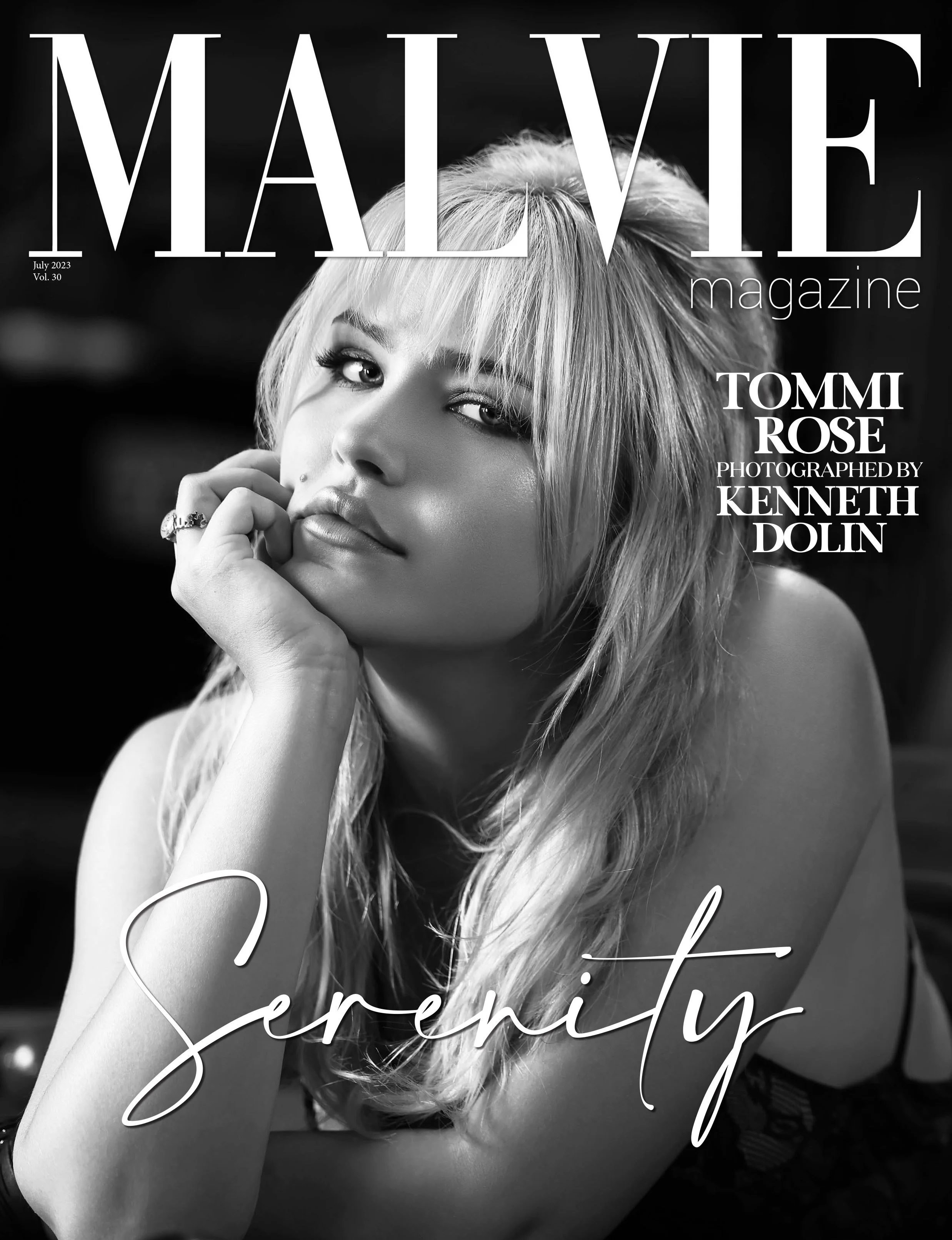 Black and white magazine cover featuring a woman with long blonde hair, resting her chin on her hand, with the words 'Serenity' and 'MALE VIE magazine' on the cover.