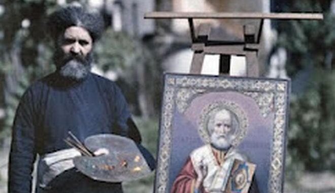   Painter monk from Mount Athos next to his work depicting Saint Nikolaos  