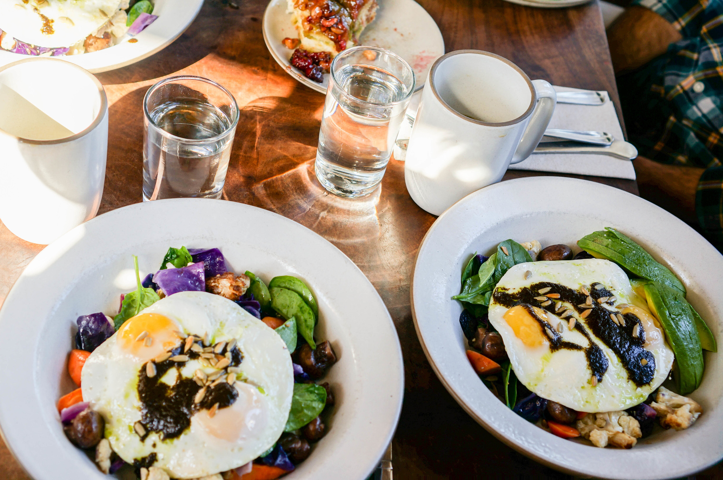 Vegetable Hash with sunny side up eggs, ginger, sunflower seeds, and black garlic.
