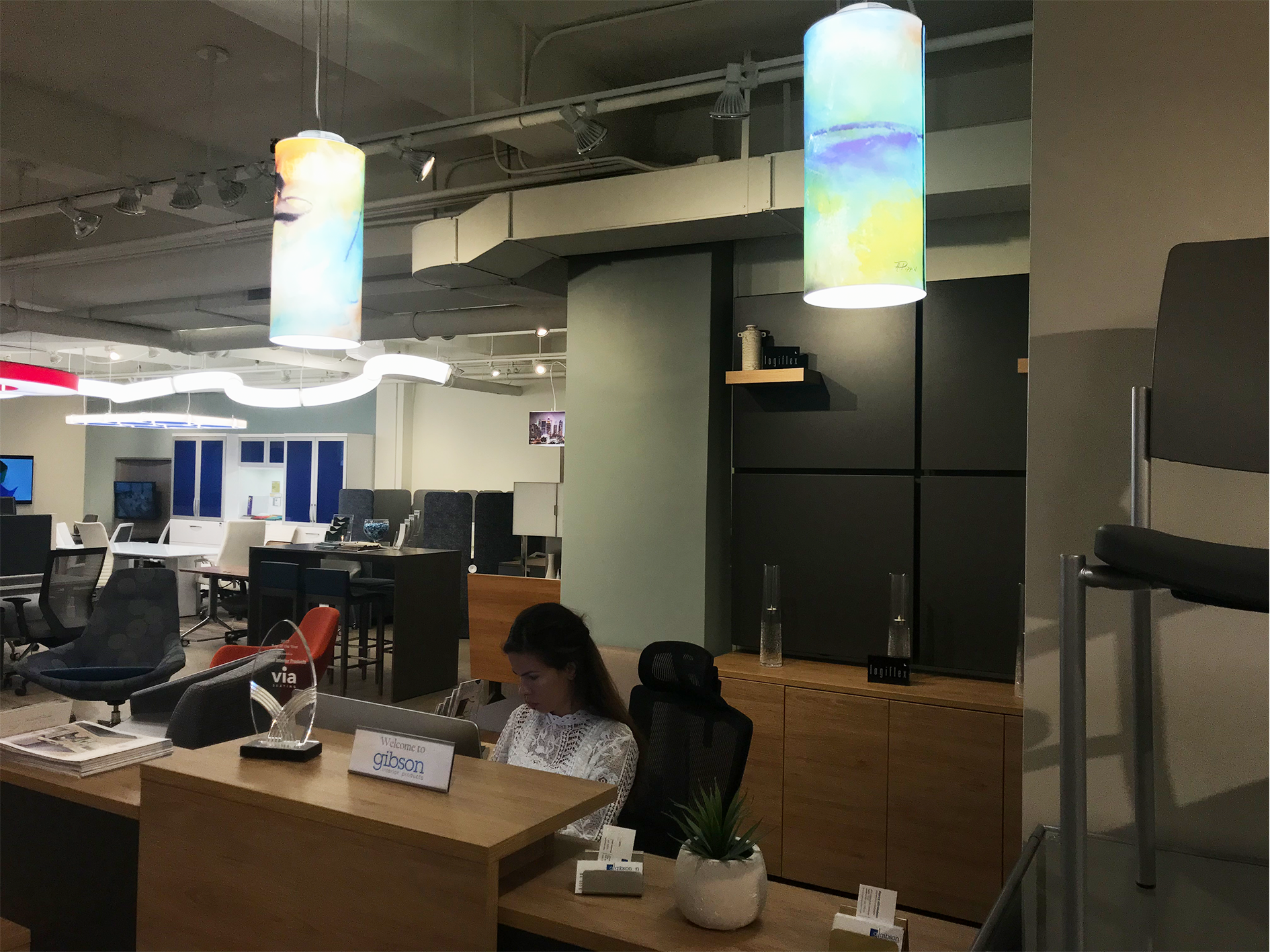 Above the receptionist desk, you will see two outstanding fixtures with beautiful prints on it. These are the Tubular pendants, available in a giant variety of colors and prints. Lit from a six-sided internal board and heat sink system, the pendants are lit from top to bottom with a full and consistent performance. These fixtures were placed right at the front of the showroom, giving anyone walking in a taste of just one of the beautifully designed fixtures placed in the showroom.