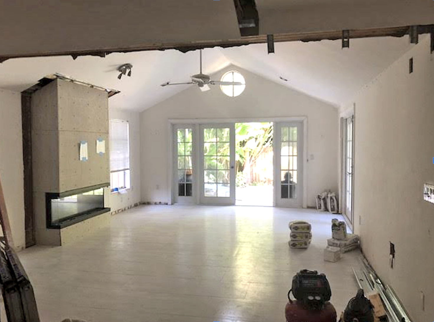 Luxury home renovation in Coconut Grove by Exclusively to Design showcasing the raw preconstruction phase with exposed ceiling joists, open partition framing, and structural site management.