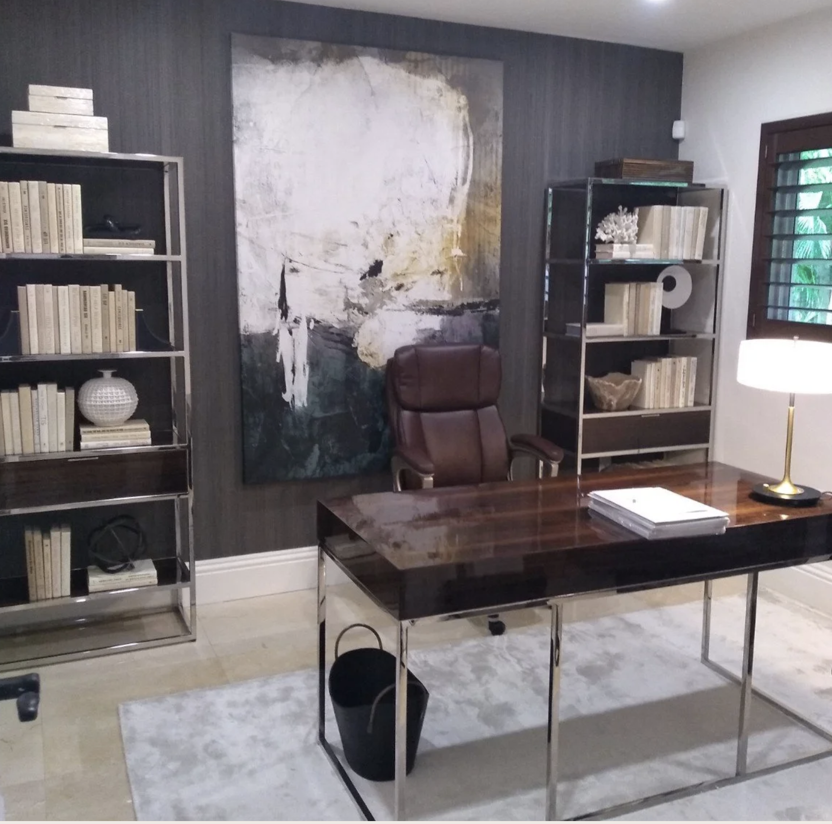 A sophisticated home office design by Exclusively to Design  featuring a curated tonal library, gunmetal chvron wallcovering and mirror lacquer dk walnut furnishings.walnut