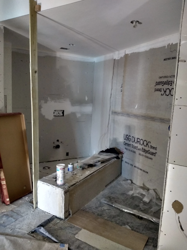 Master bathroom construction in South of Fifth Miami Beach penthouse showing glass shower enclosure build out and partition bench installation