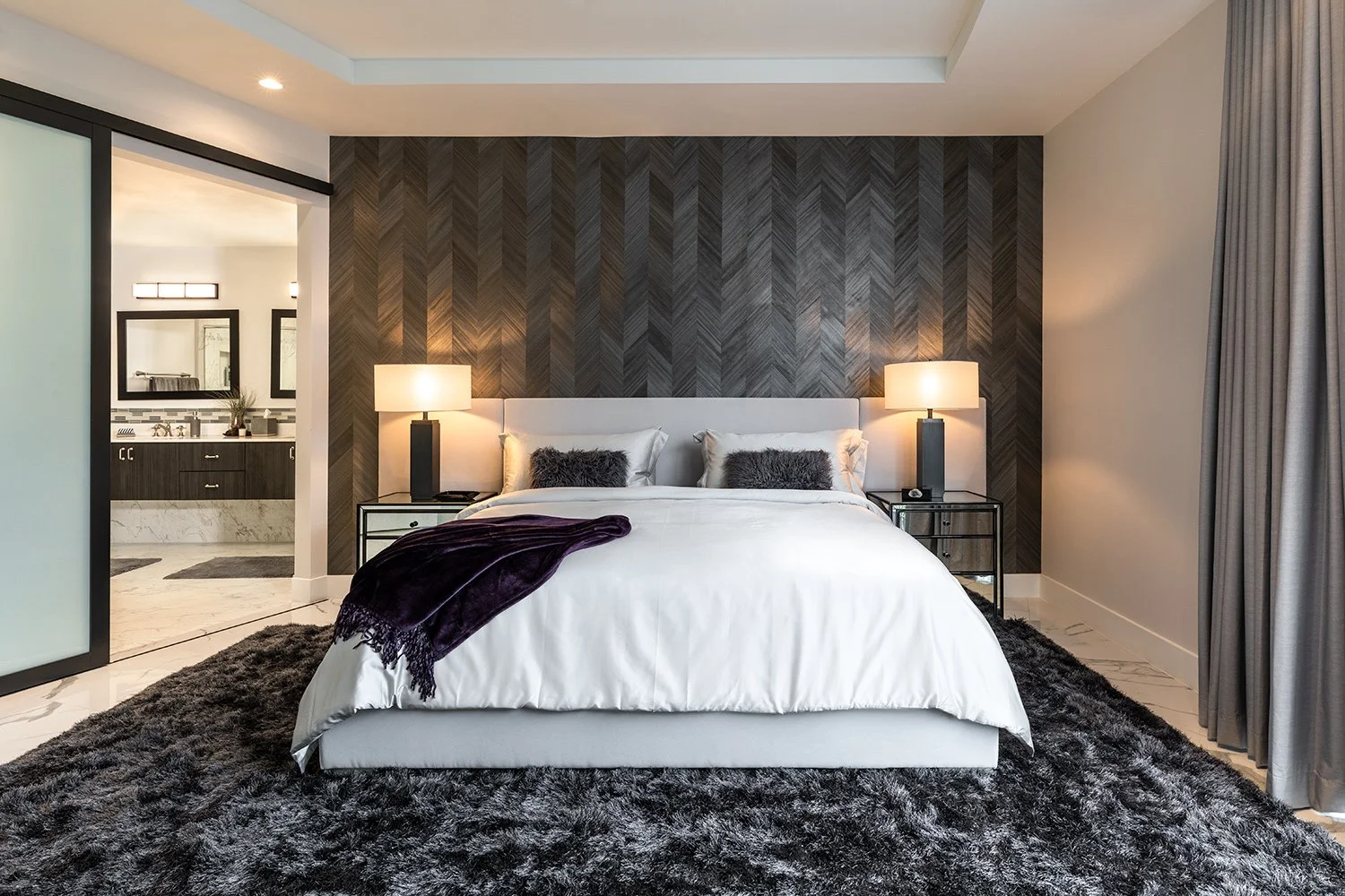 Ft. Lauderdale penthouse master suite evolution with mood and rich textures like wood cut wallcopvering in a deep charcoal chevron pattern and Italian bedding.