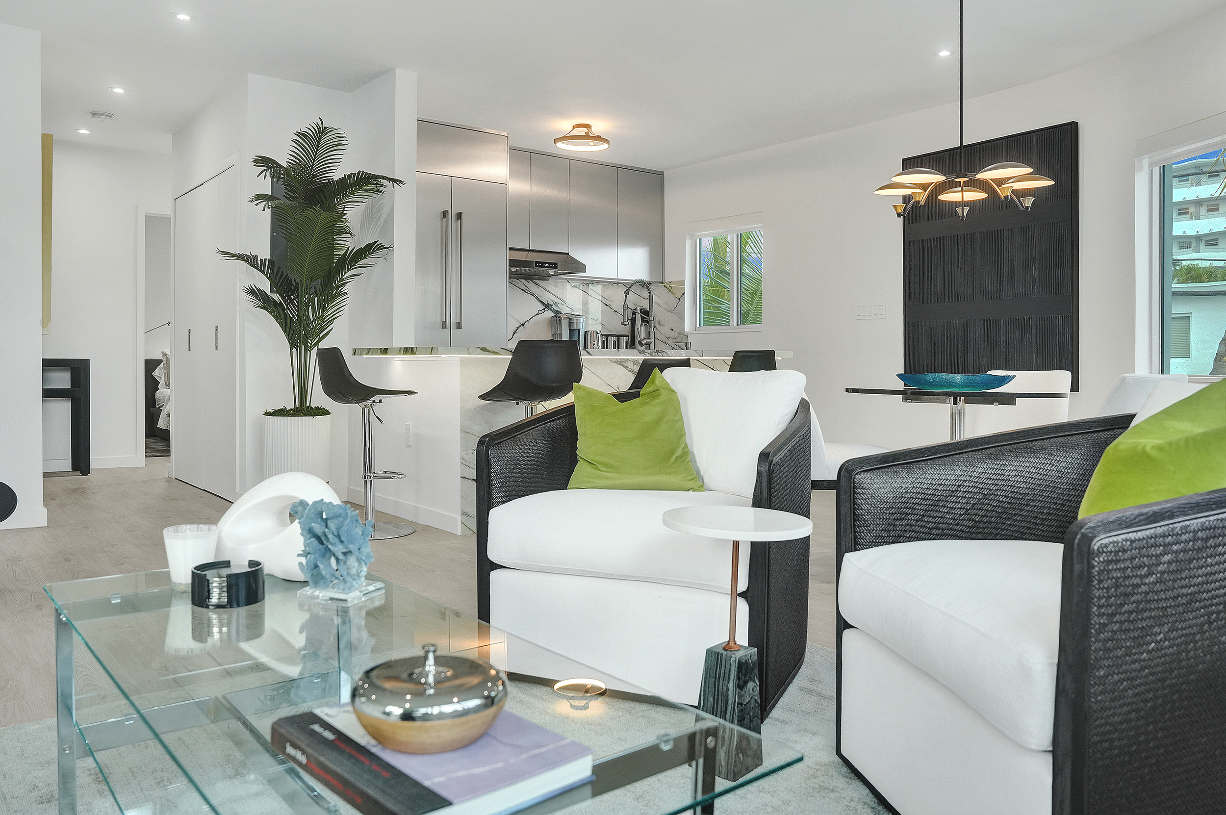 Miami Beach luxury living room with black rattan swivel chairs, postmodern furnishings, and modern coastal interior design