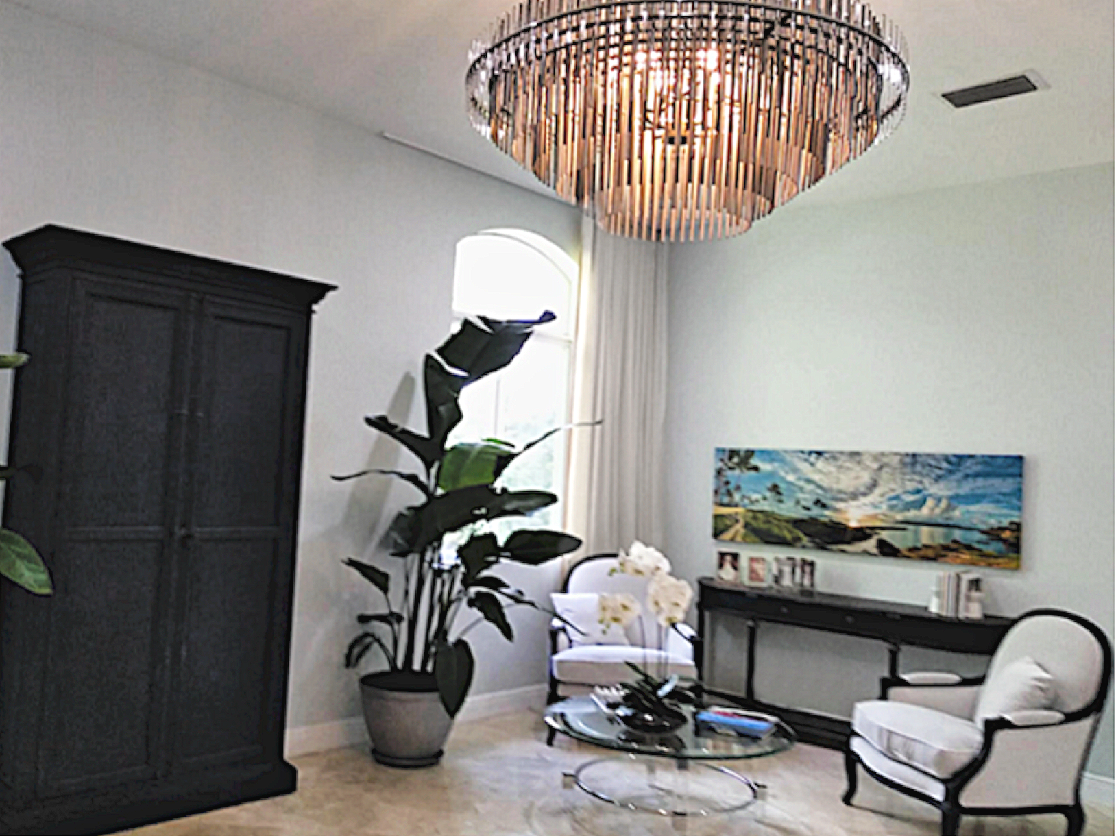 Coral Gables master suite sitting area with armoir, crystal tubular chandelier, soft light grey velvet furnishings and arched architectural details