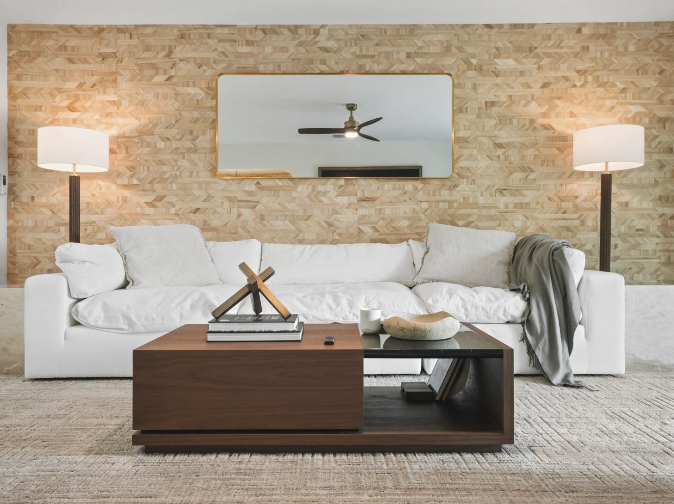 Miami vacation rental living room with textured feature wall, white sofa, wood coffee table, and warm Tulum-inspired styling.