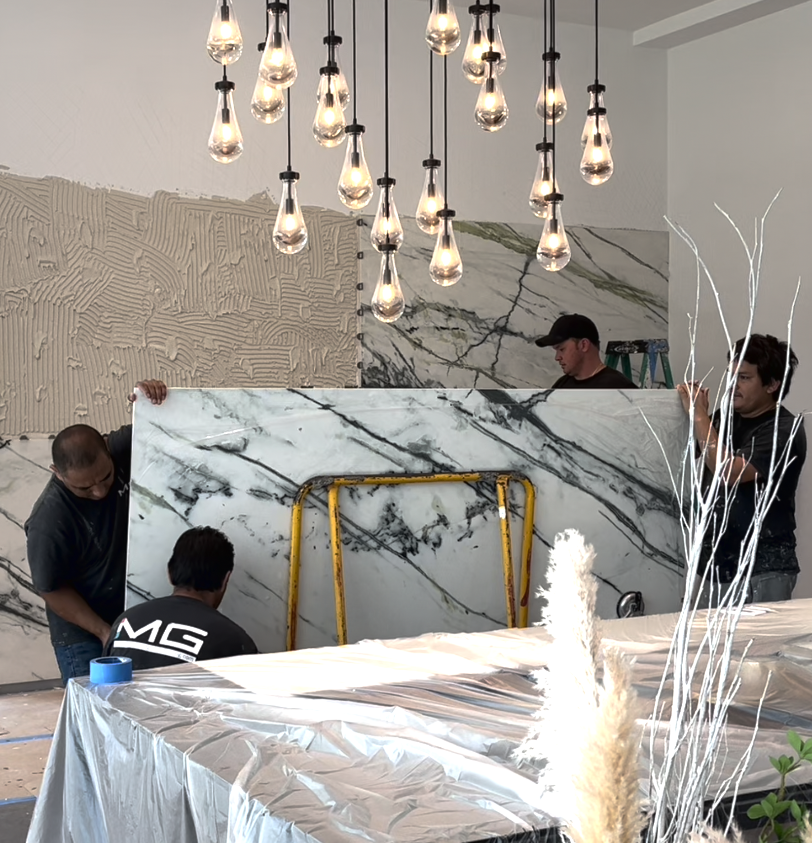 Green Calacatta porcelain slab feature wall installation in dining room during renovation of Hibiscus Island Miami Beach luxury residence