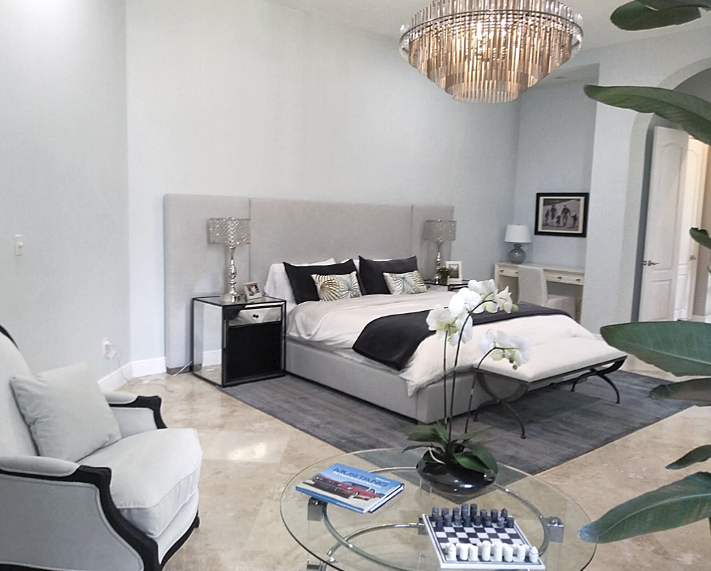 Coral Gables master suite renovation with upholstered bed, neutral palette, and dramatic tubular chandelier