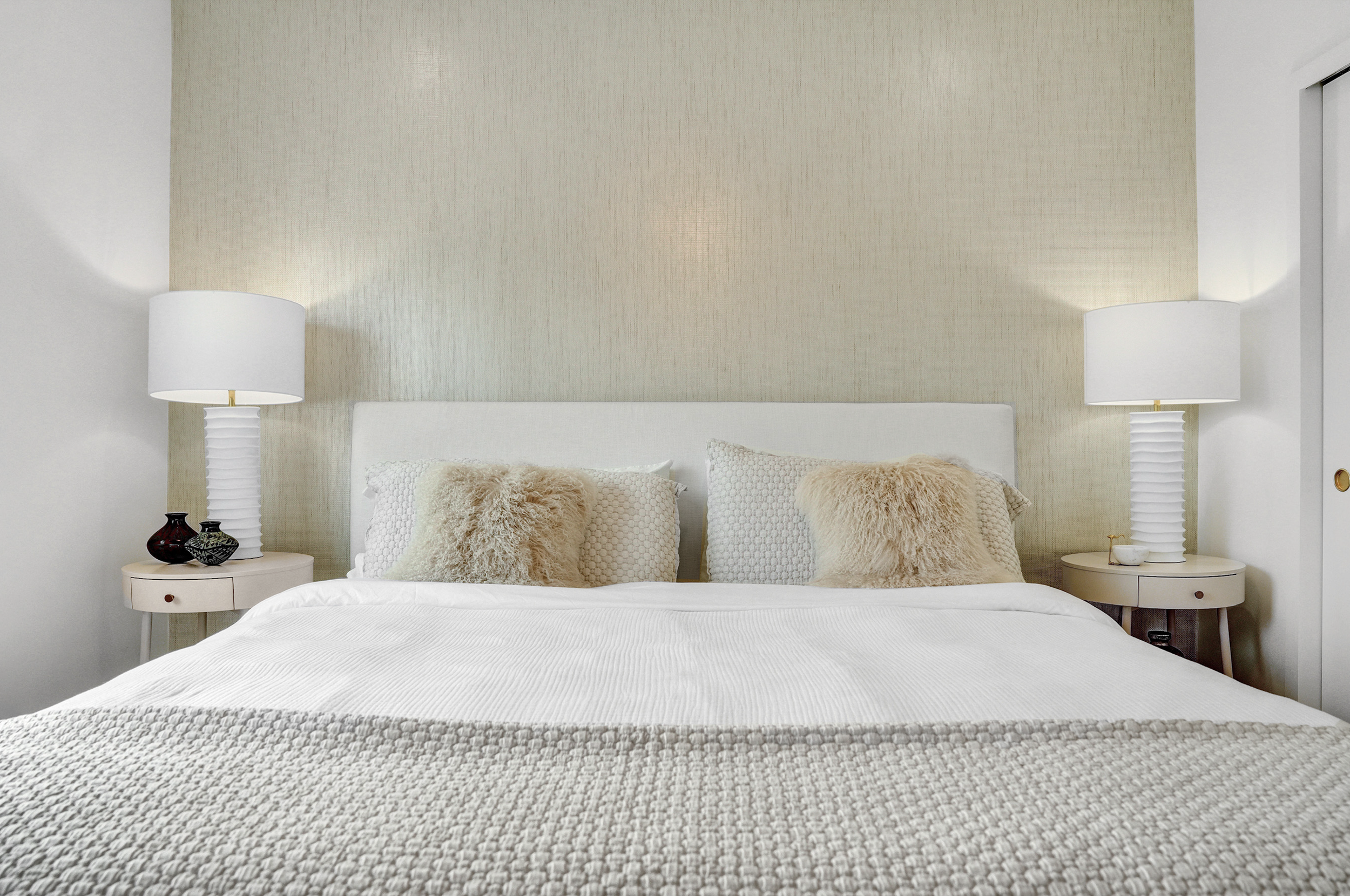 organic coastal master bedroom design after renovation in historic miami beach investment condominium with soft layered neutral styling