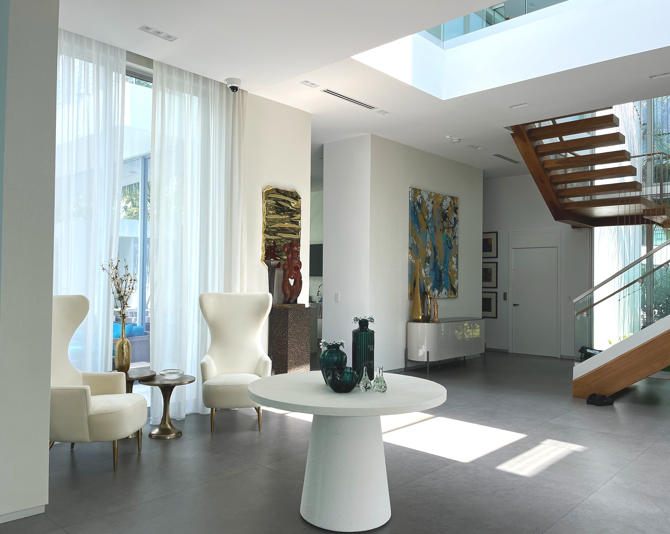 Contemporary foyer design in prestigious Hibiscus Island Miami Beach residence featuring wallcovering, painted architectural surfaces, and curated decor in a dramatic double height entry space