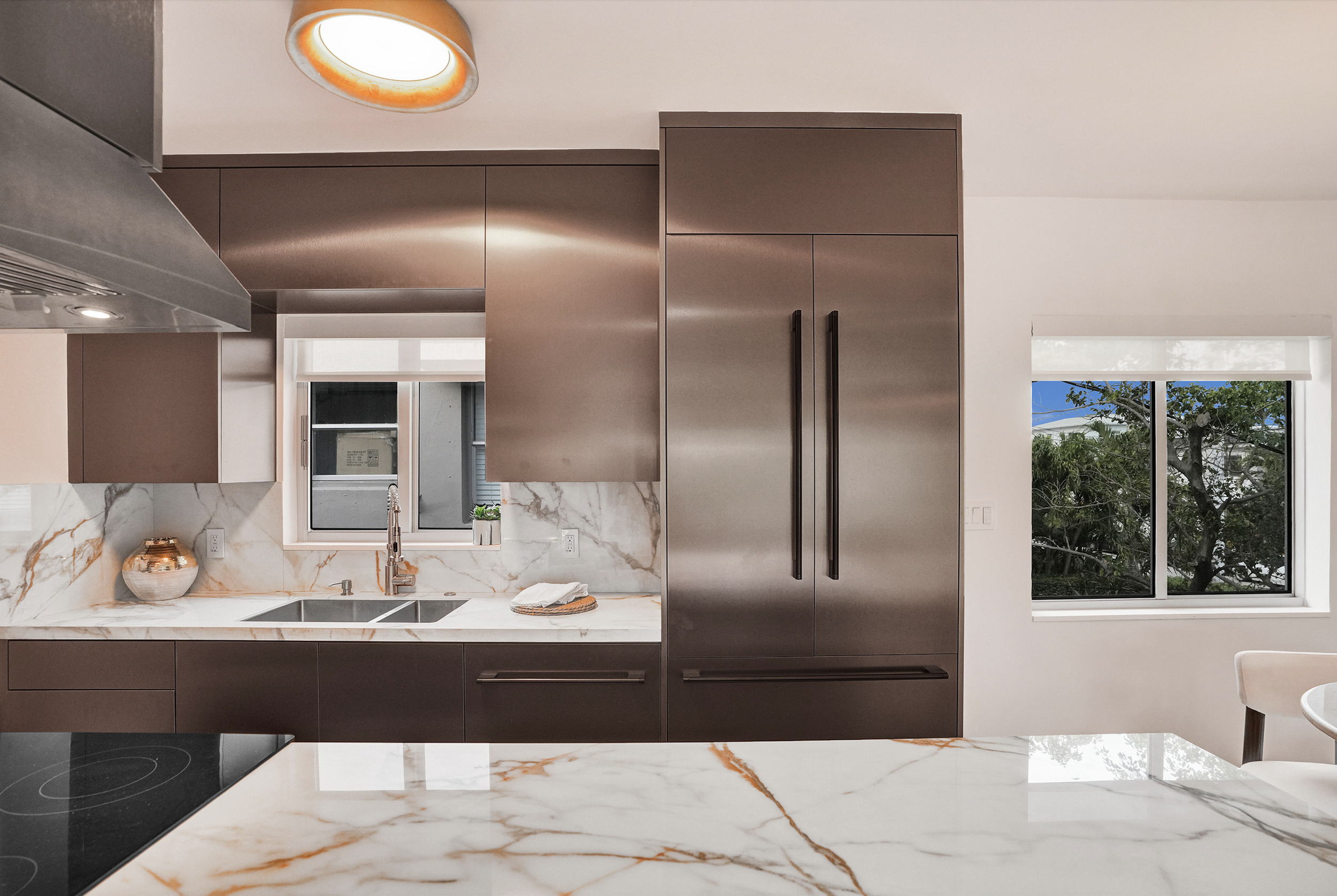 Miami Beach condo structural and kitchen remodel featuring bronze metallic cabinetry and gold Calacatta marble countertops