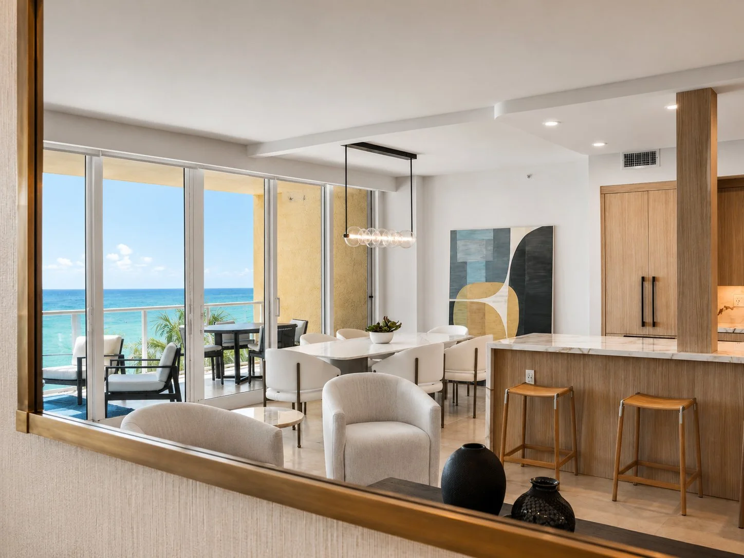 Hillsboro Beach living room and dining area with custom white oak slatted partition and Atlantic Ocean views
