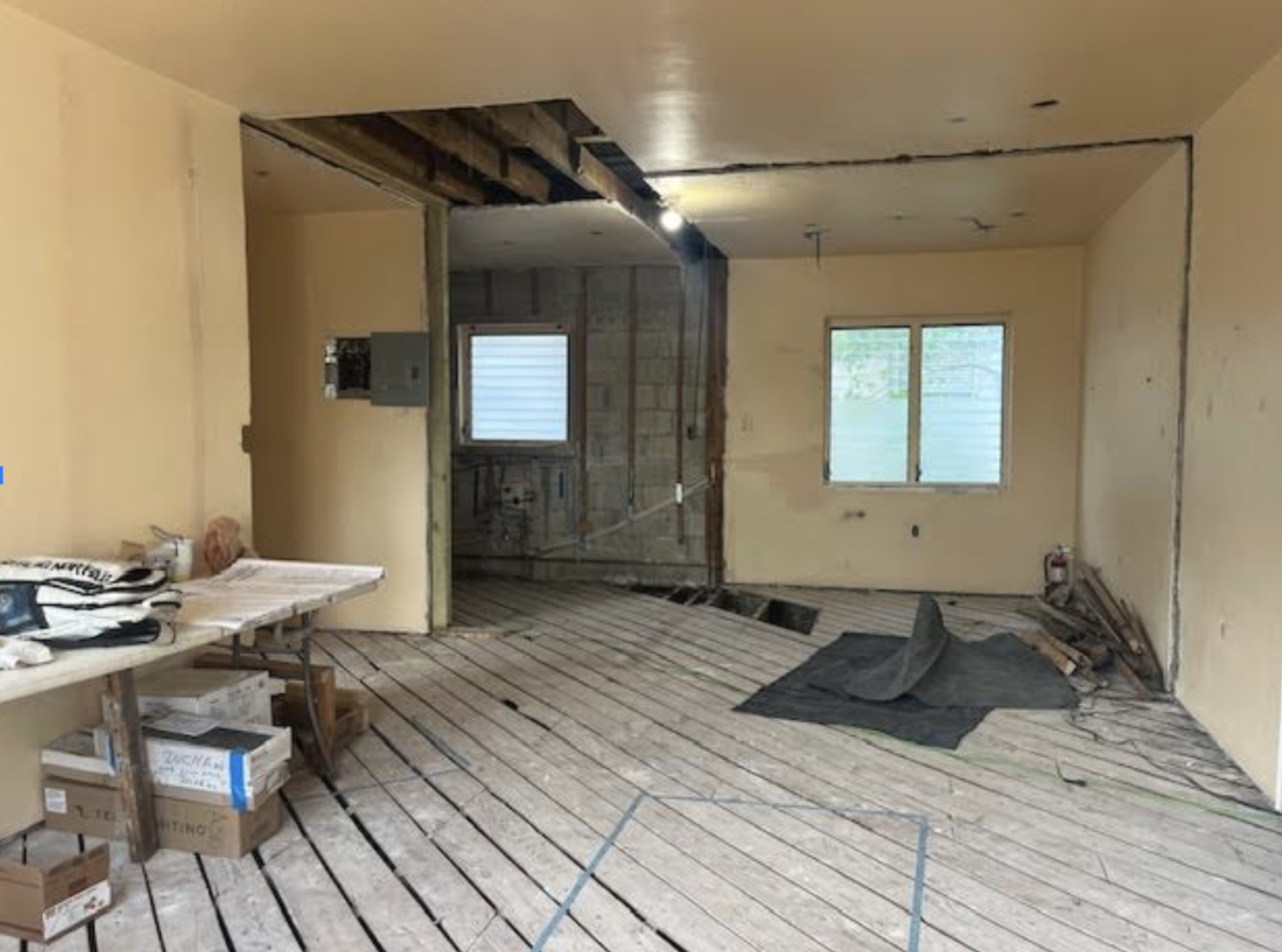Kitchen before remodeling with exposed subfloor, stripped walls, and unfinished interior structure