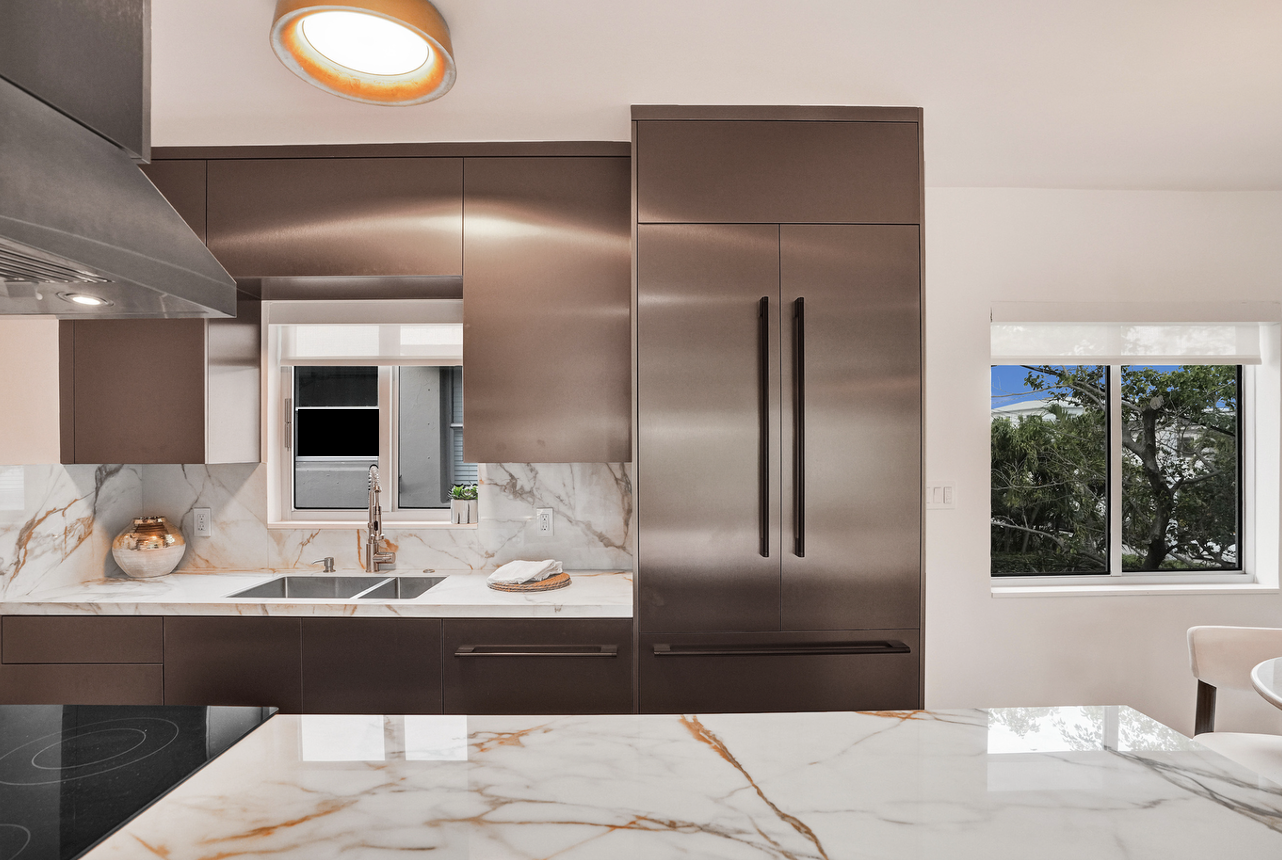 Bronze metallic kitchen with Gold Calacatta countertop in an open concept design with the dining room