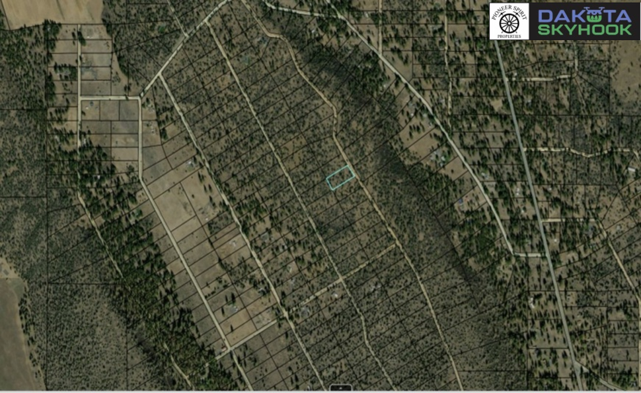 An aerial map showing a grid of roads and plots, some with trees and others cleared, in a rural area. It features logos in the top right corner for Pioneer Spirit Properties, Dakota Skyhook, and a green logo.
