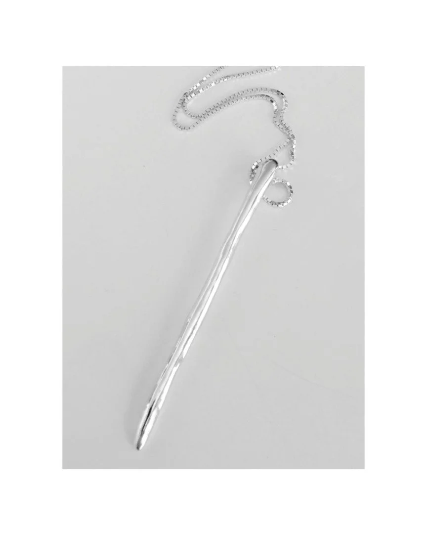 A single line, held in balance.

The Bacchetta Pendant is reduced to its essential gesture &mdash; a slender form suspended in space, cut in silver to catch light without asking for it.

It doesn&rsquo;t compete.
It defines.

Worn alone, it becomes p