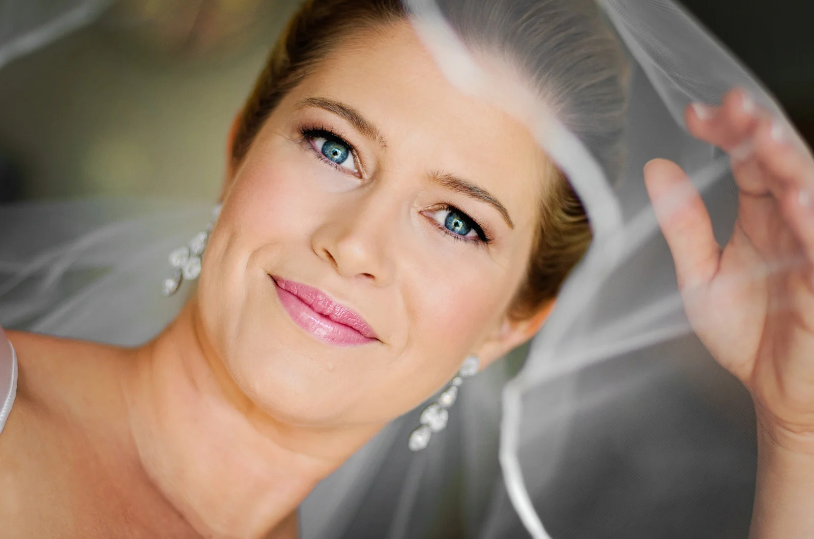 Close up of Bride peaking through the veil.