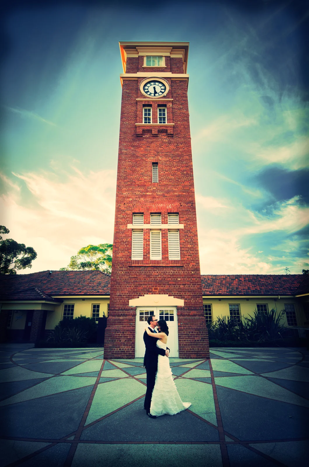 Wedding couple embracing in front of clock tower at Heathcote Reserve. South Perth