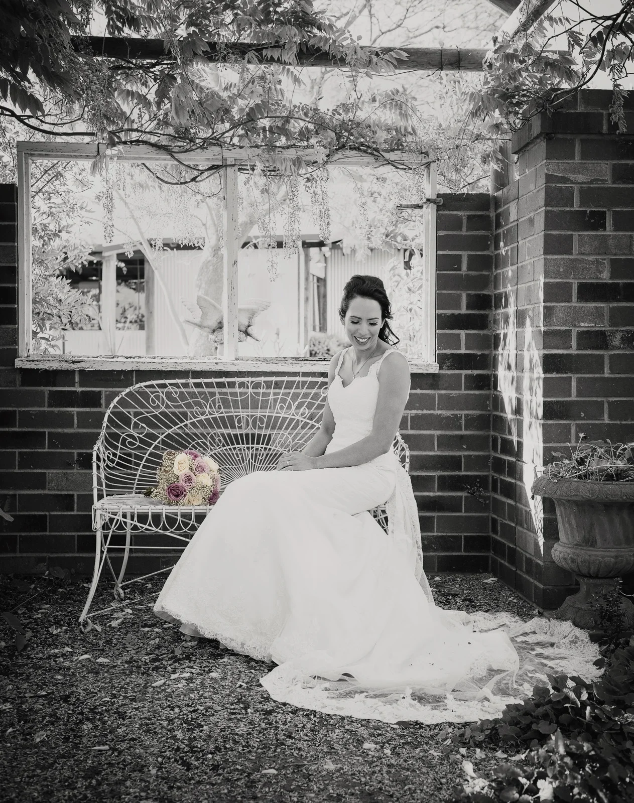 smiling bride sitting on ornate seat at Barrett Lane in B&W. Swan Valley