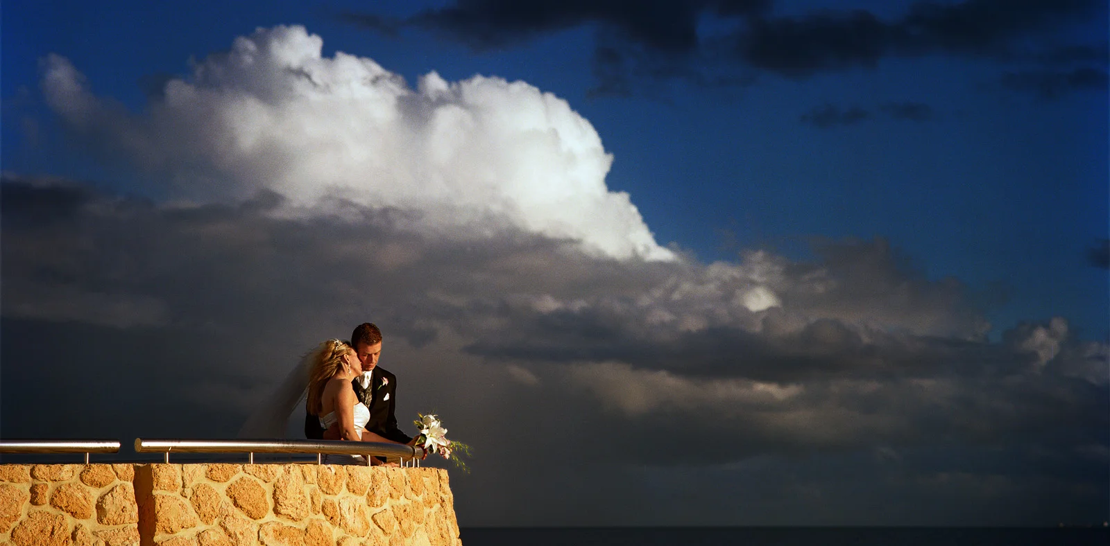 Wedding couple under a white cloud during storm at Scarborough beach