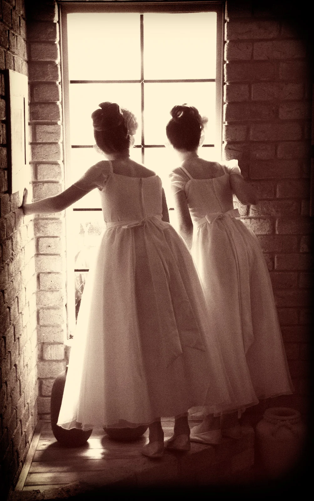 Two Flower Girls look out of window waiting for the limo to arrive.