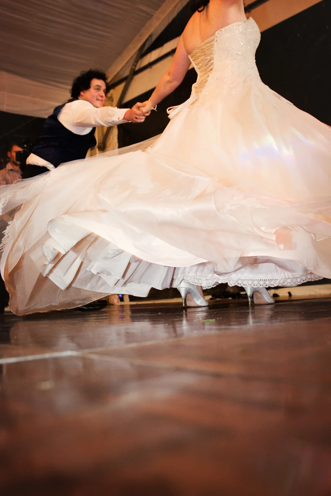 low angle creative shot of Bride and Groom dancing with dress flowing