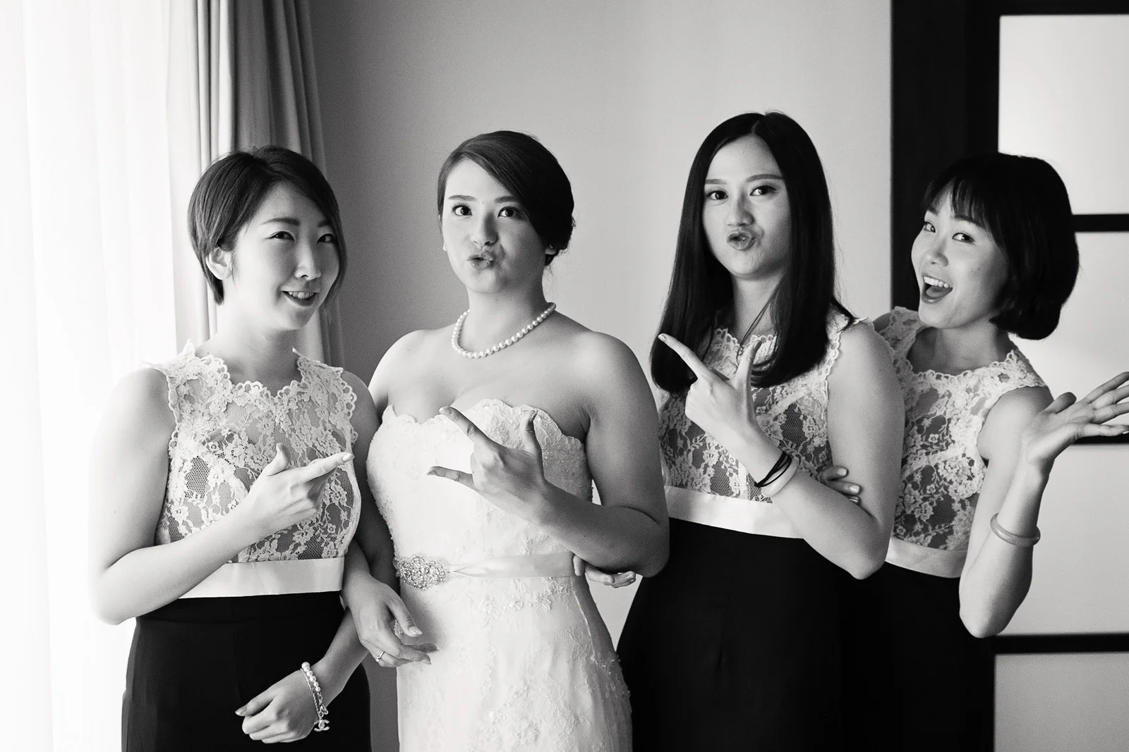 fun Bride with her bridesmaids pose for camera at home