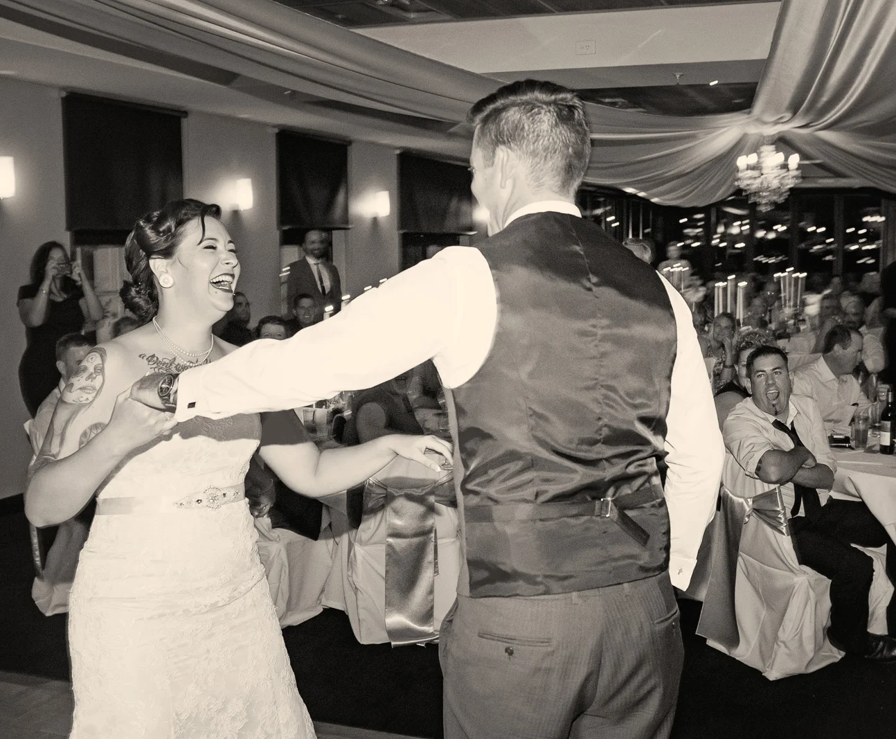 Beautiful happy moment of bride and groom dancing with cheers from guests