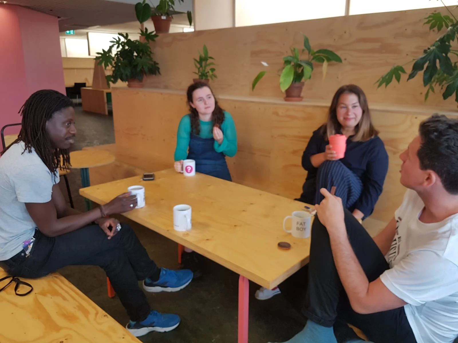 Four colleagues sat around a table at the recreation room on our floor, discussing how to keep plants alive