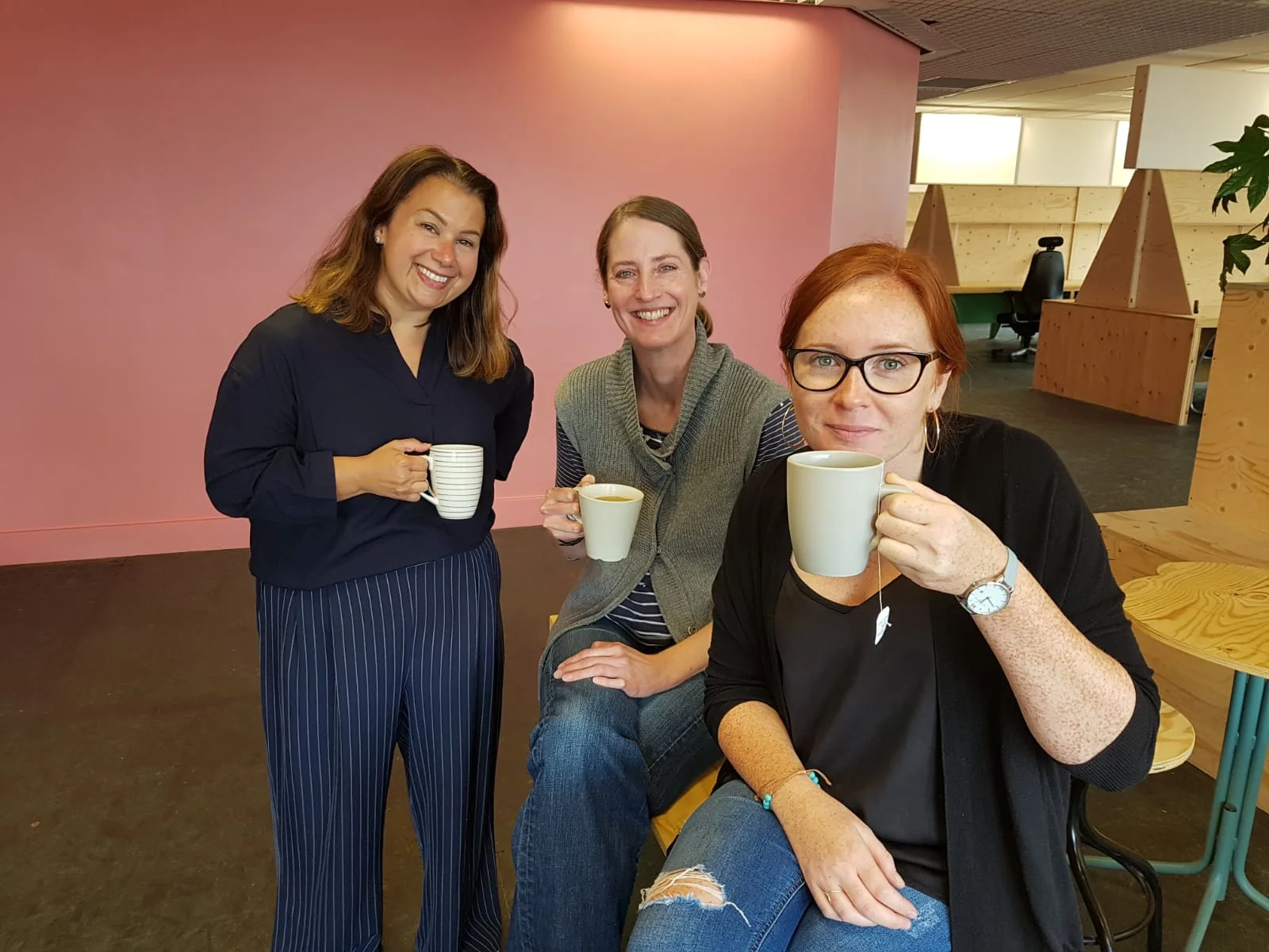 Our CEO Taryl pictured with two of our friends from Synergy Theatre, who are smiling at the camera and holding their mugs of tea