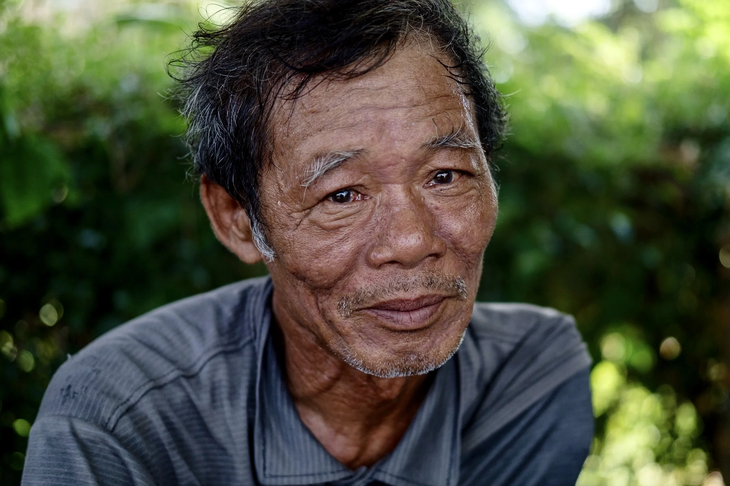 A war veteran we met at a roadside café. He was building a bridge at night with other soldiers when they were discovered by the Americans and bombed. They moved to a different location and started building another bridge, and they were bombed again - the second time he lost his arm.