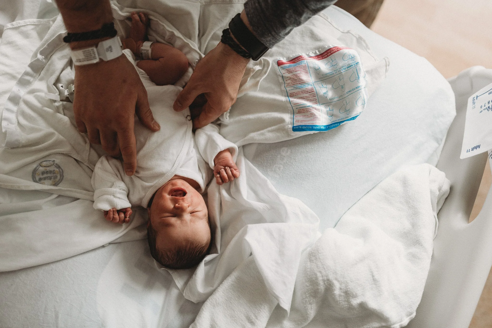 Newborn baby swaddled in blanket during Fresh 48 session