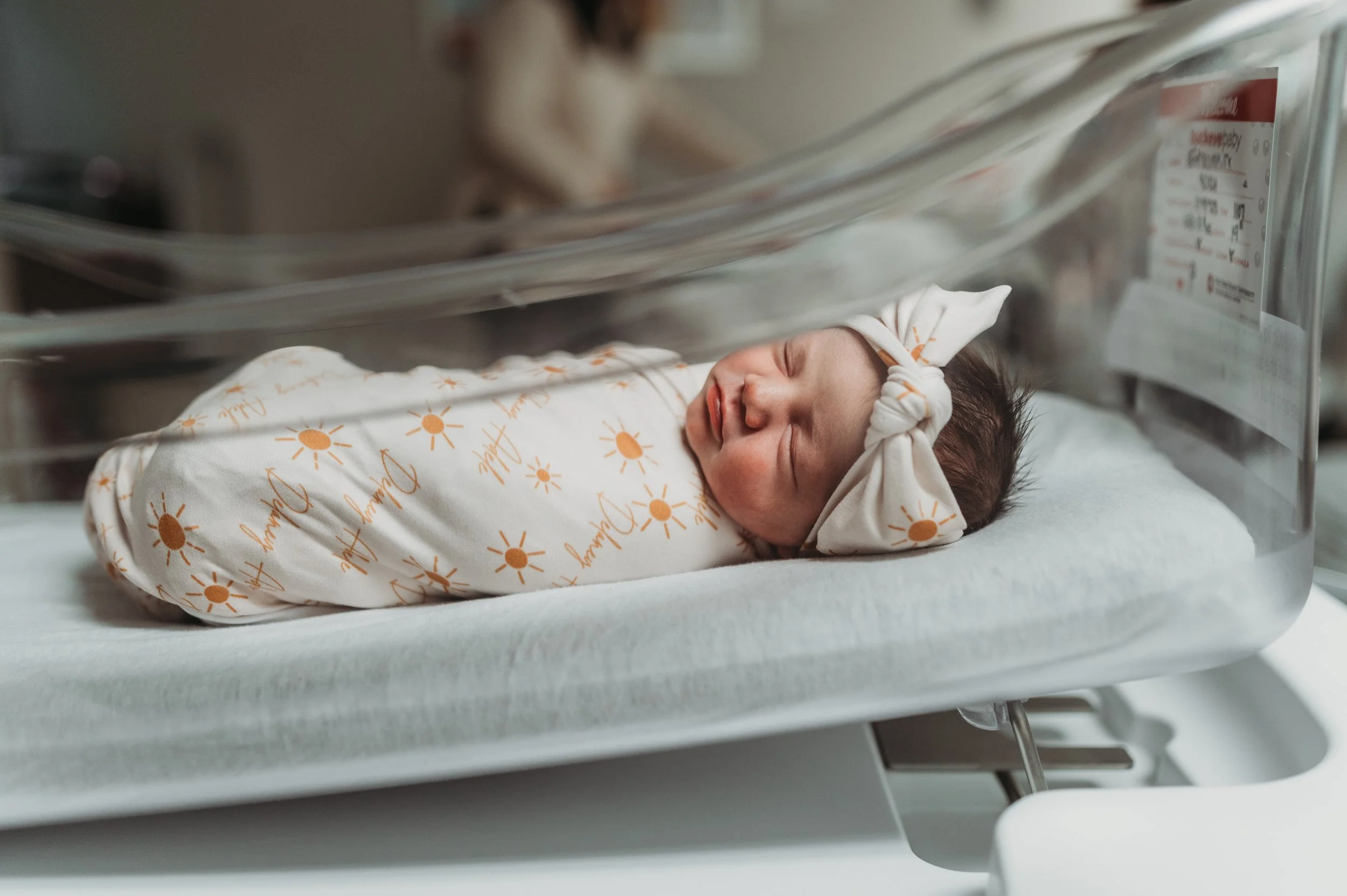 Newborn baby swaddled in hospital bassinet during fresh 48 session