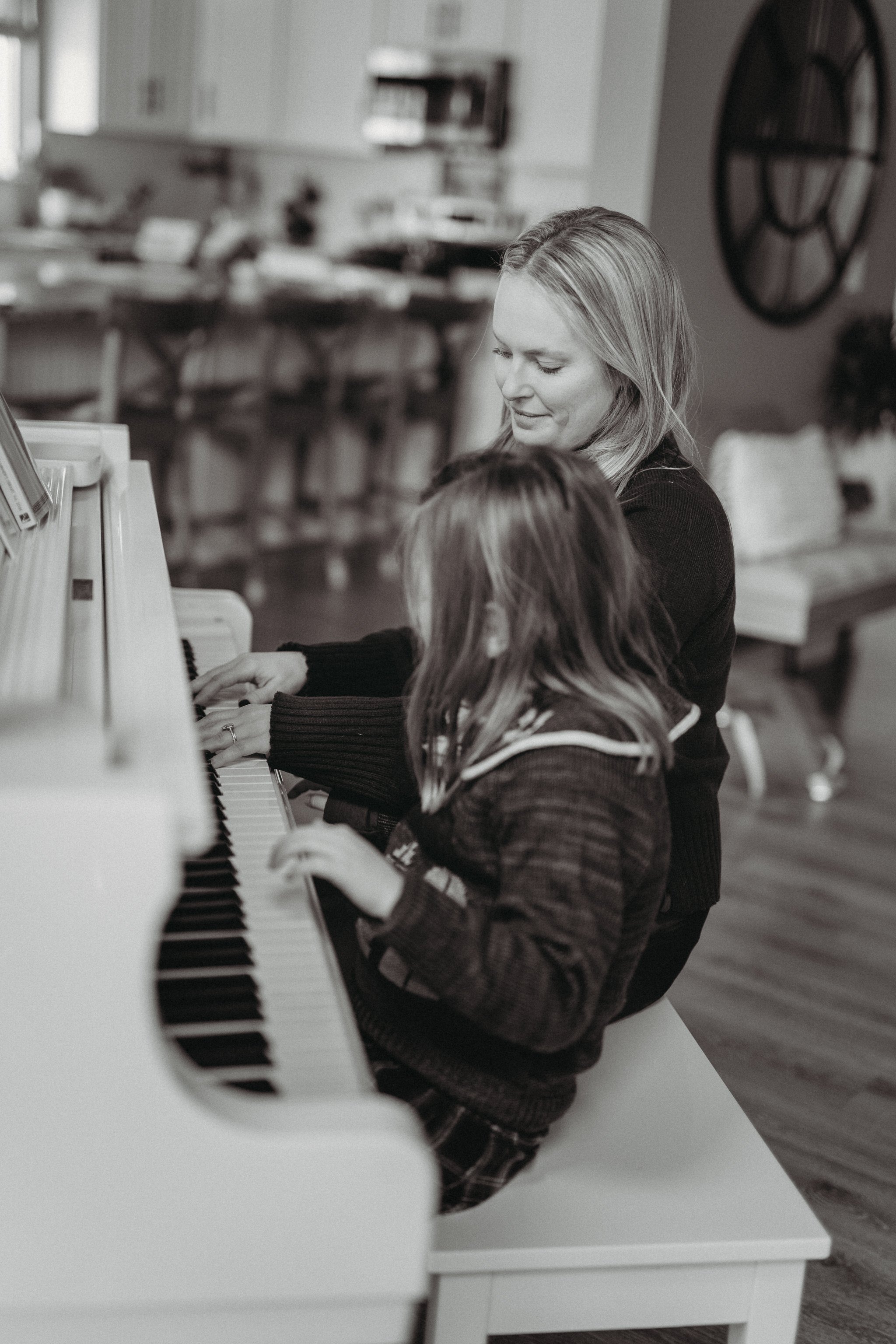 Mom playing piano with her daughter