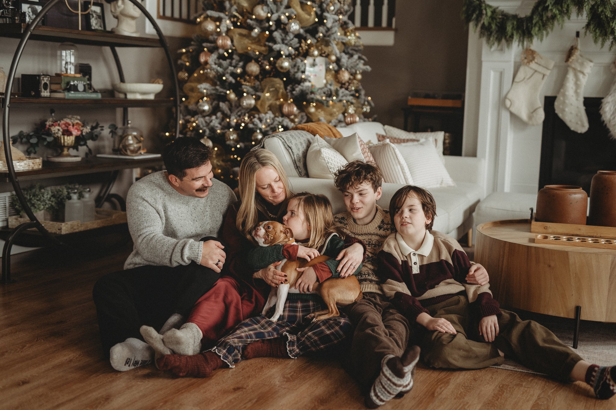 Family sitting in front of their Christmas tree 