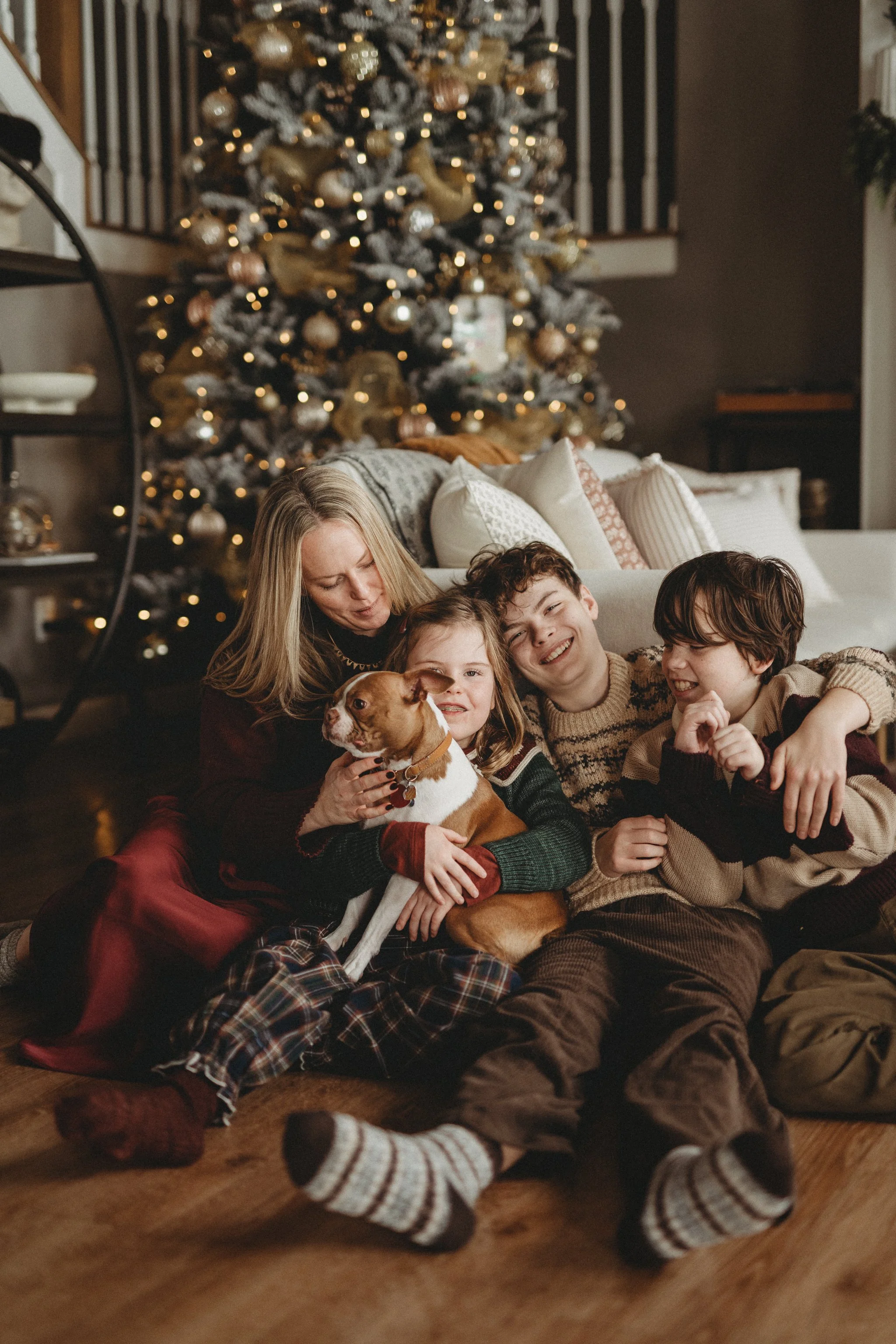 Mother cuddles with her two sons and daughter during in-home family photos