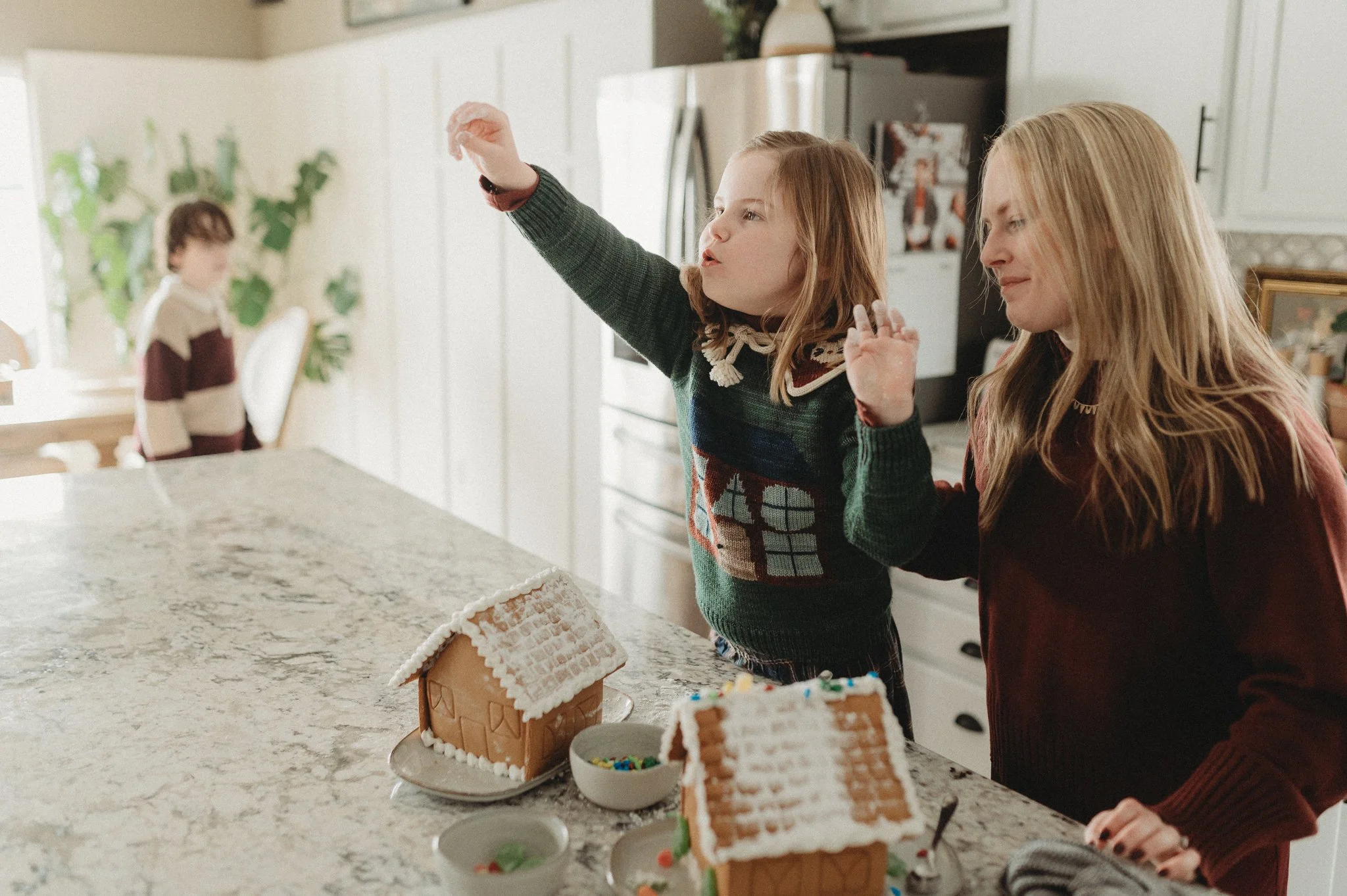 Mother and daughter decorating gingerbread houses