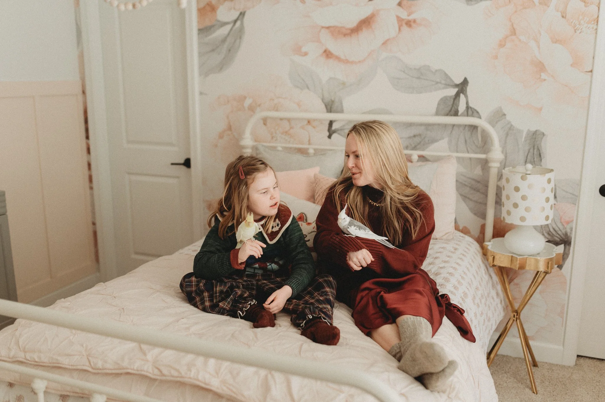 Mother and daughter holding pet birds during in-home family photos