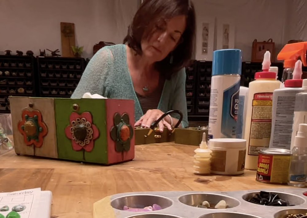  Karen Adler refreshes a vintage Enid Collins "Glitterbugs" mini box bag. Look closely and you'll notice two copies on the table. Adler refers to original, authentic examples from her collection so that works are restored correctly. Credit: Michael M