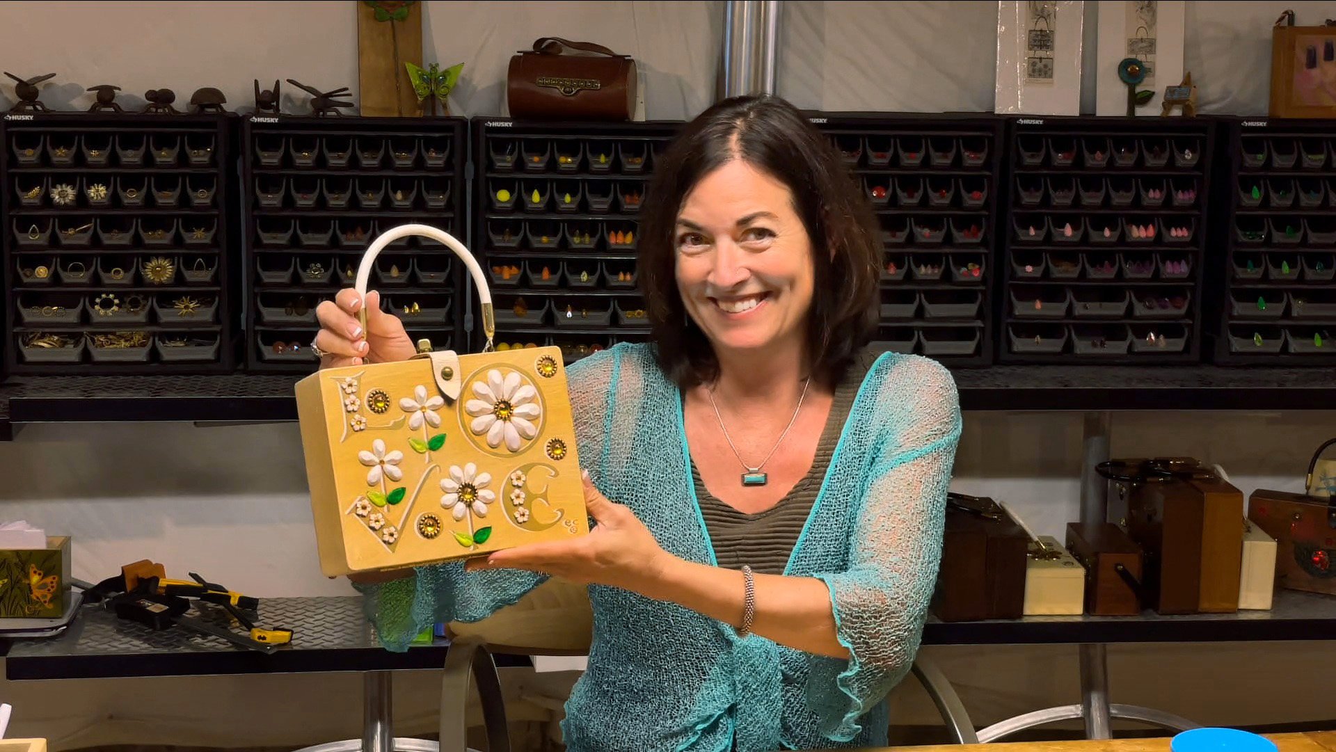  Karen Adler holds the bag that started it all for her: a 1968 "LOVE" box bag she discovered in a Chicago thrift store in 2011. Credit: Michael Maloy, 2022 