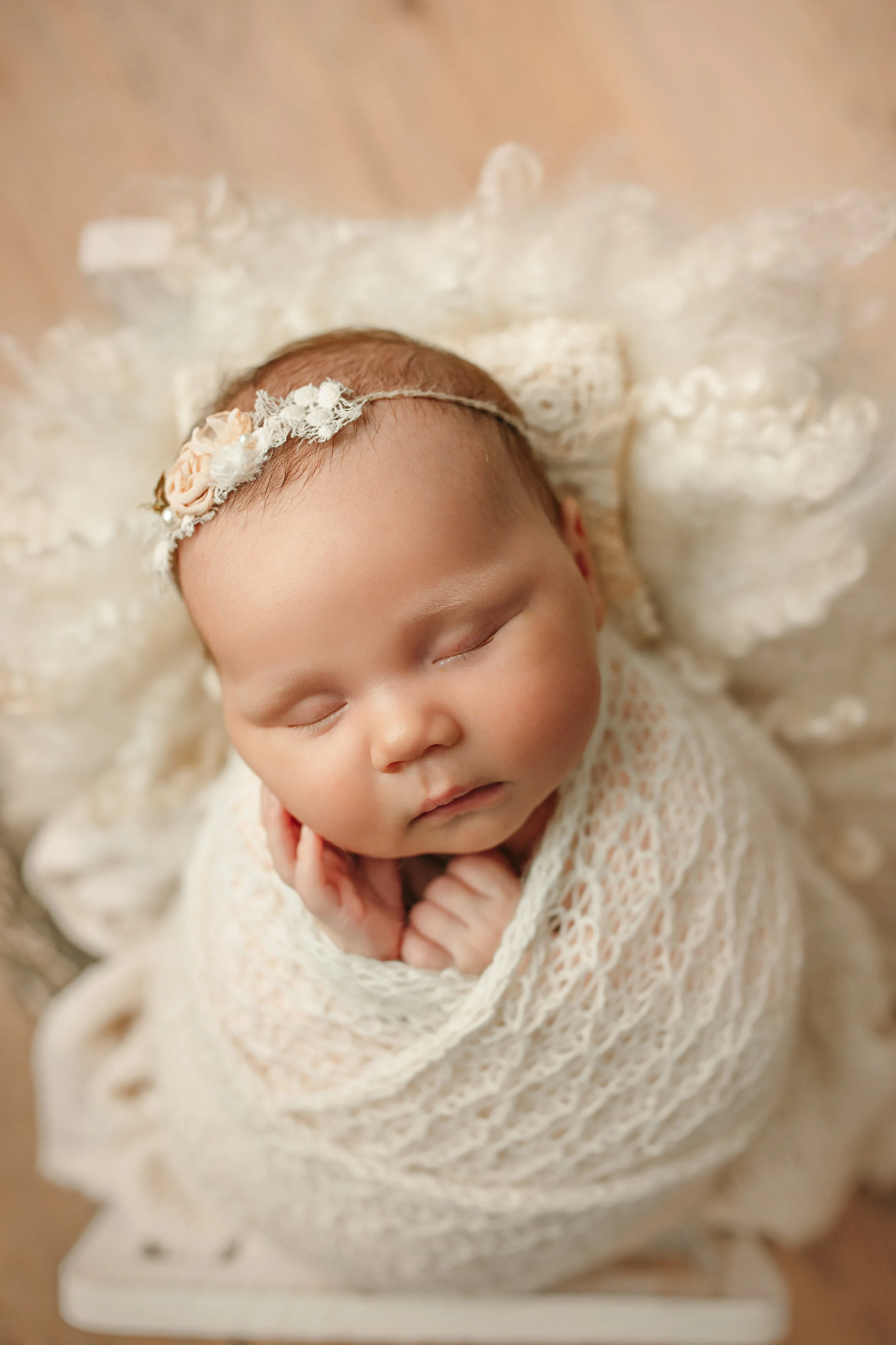 Newborn baby girl wrapped in lace on white and sleeping during newborn session at Chasing Sammi Photography studio in Springfield Missouri