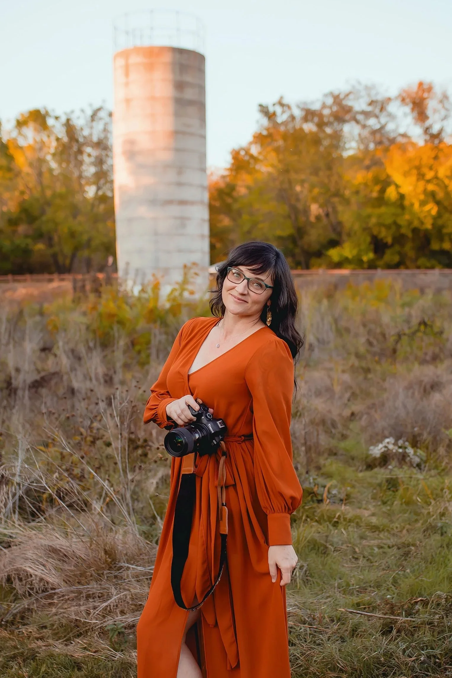 Jessica Gaines, photographer and owner of Chasing Sammi Photography in Springfield Missouri holding camera and looking at the camera