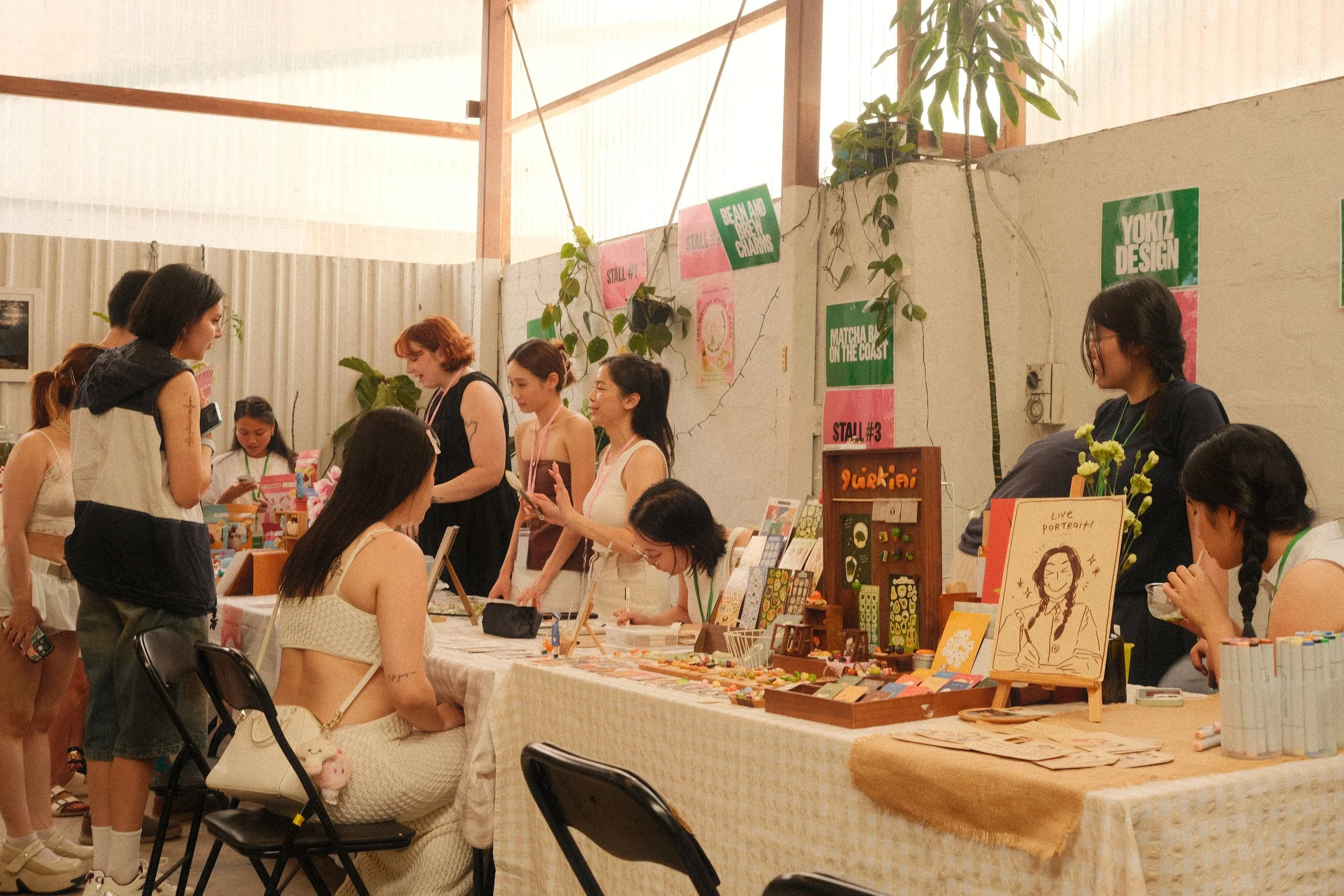 People browsing craft tables at an indoor market event with various handmade items at Nauti Studios Sydney.