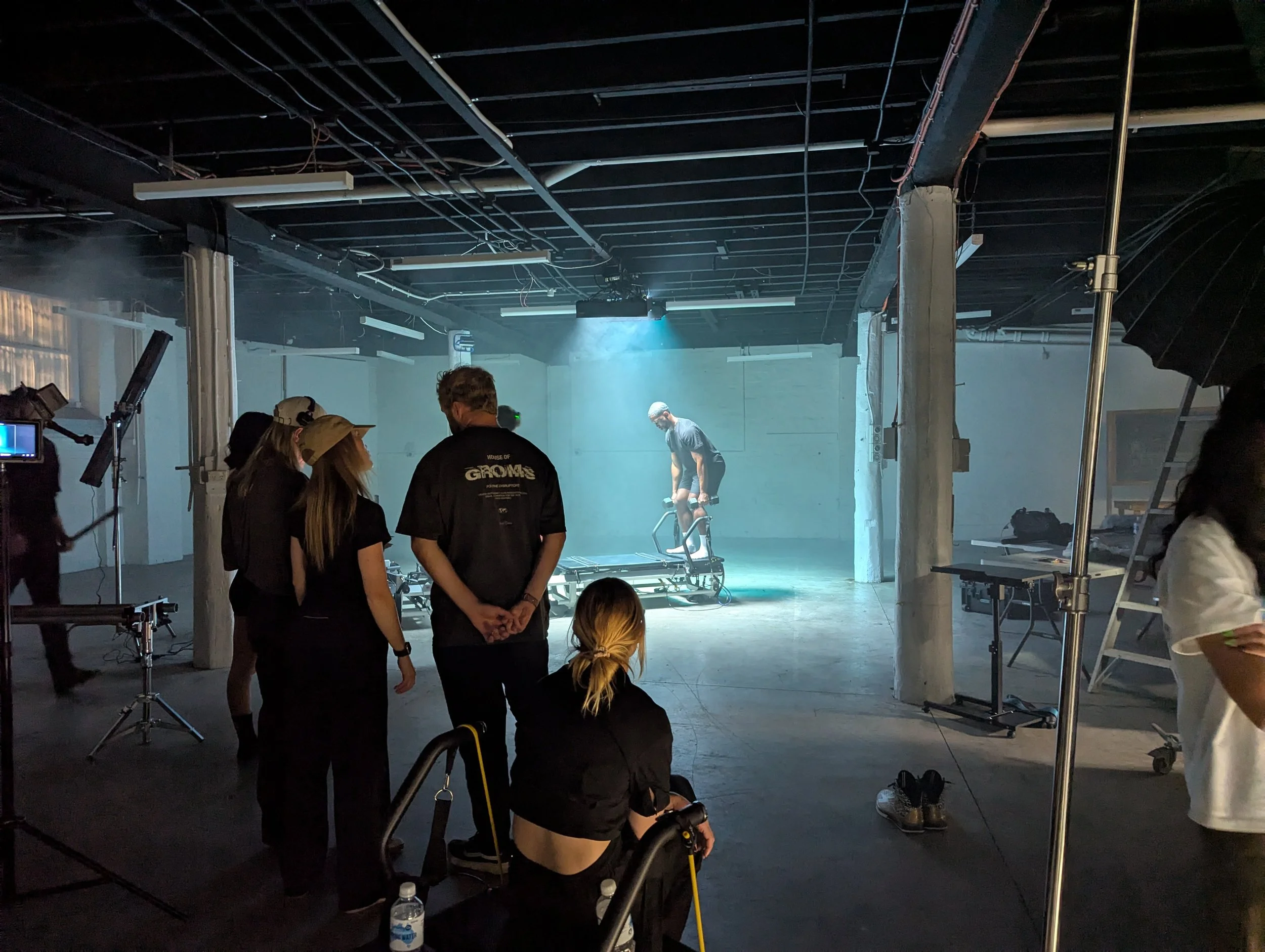 Film crew on set with a model in the photoshoot industrial space The Deep at Nauti Studios Glebe, with equipment and crew members observing.