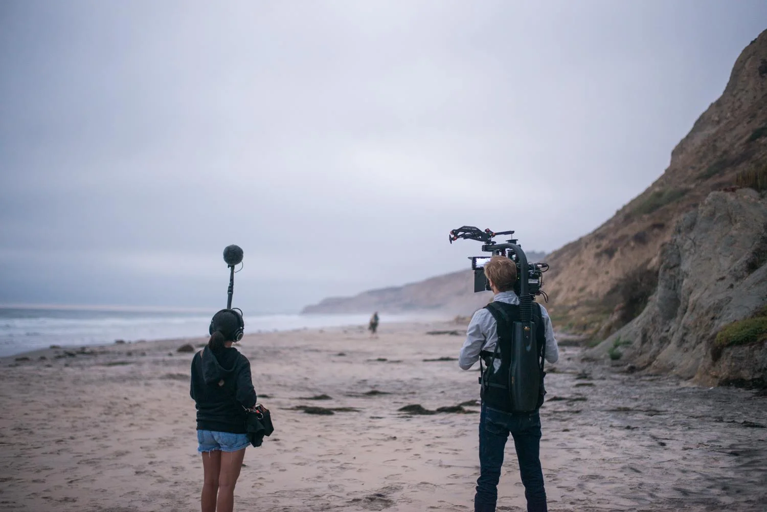First day of production on Black's Beach in San Diego, CA. Noah is in the distance with the actors blocking the shot with a wireless monitor, as Dan frames the shot. Alanah on sound. Photo by Clint Hess.